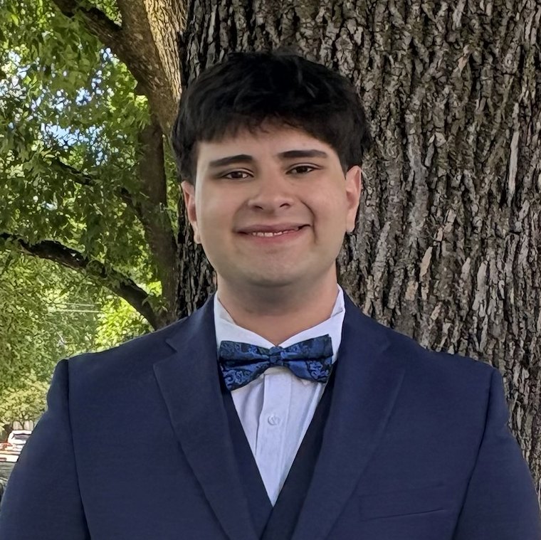 Josh, the photographer, smiling in a navy suit and bow tie
